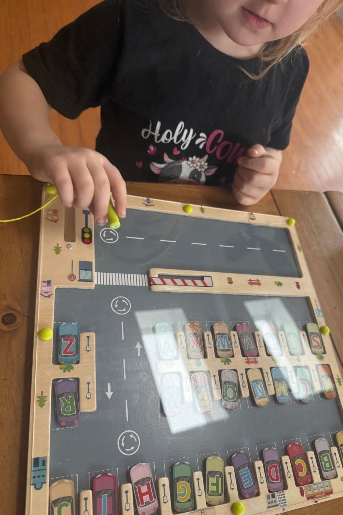 A child working on letter recognition with a puzzle game.