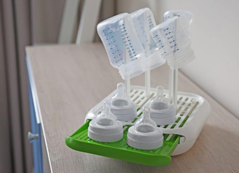 Clean baby bottles on a drying rack.